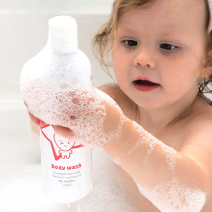 Winxsta Kids body wash 300ml - cute toddler holding up body wash in the bath with bubbles covering her hands.